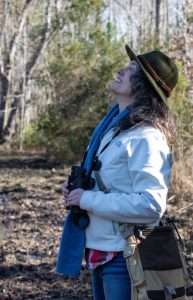 Professor Melissa Hughes in the field with binoculars